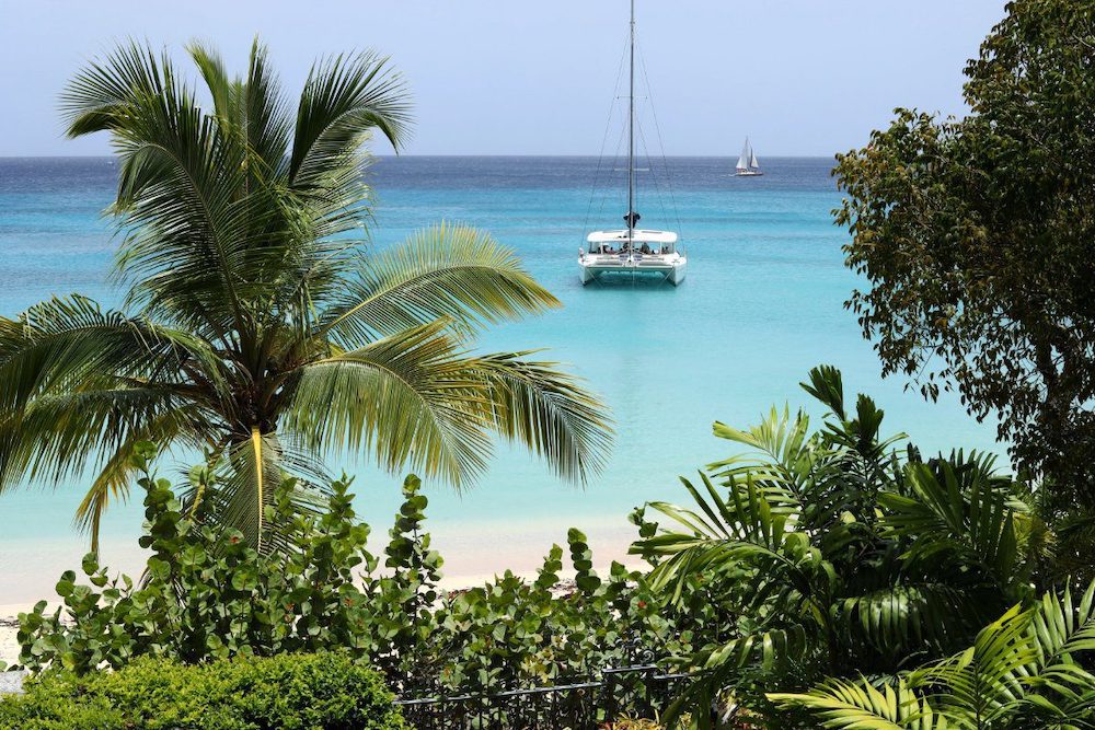 One of the top beaches in the Caribbean for a luxury holiday, covered in white sand and palm trees, in Paynes Bay, Barbados.