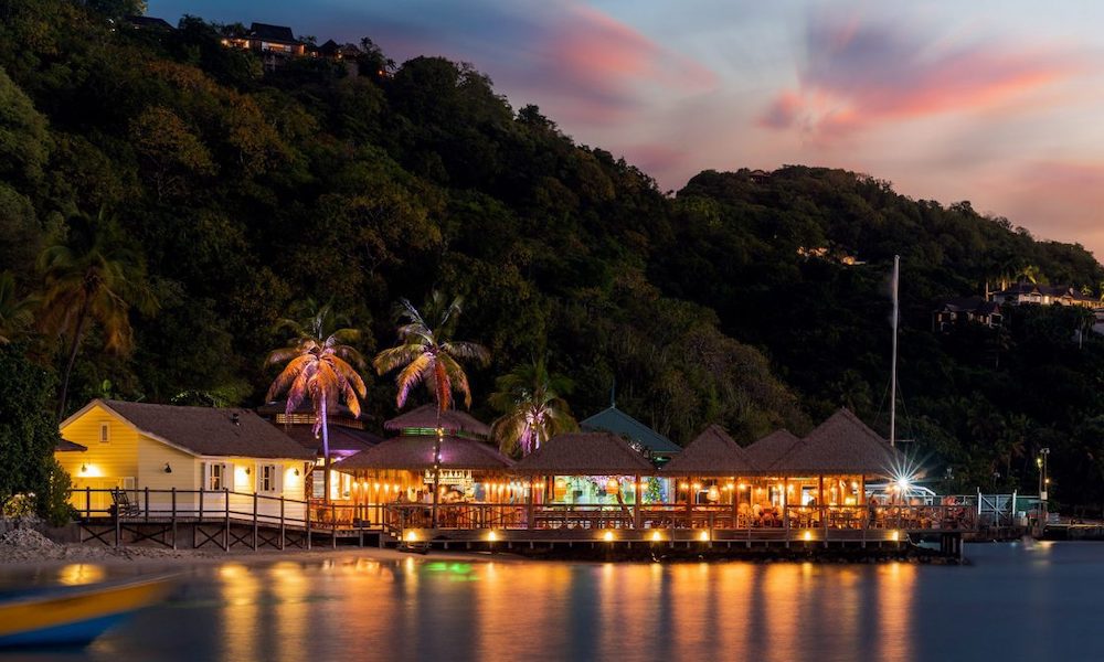 An amazing restaurant on Mustique in the Caribbean is Basil's Bar, a seaside bar and restaurant pictured here at dusk, lit up and reflecting on the water.