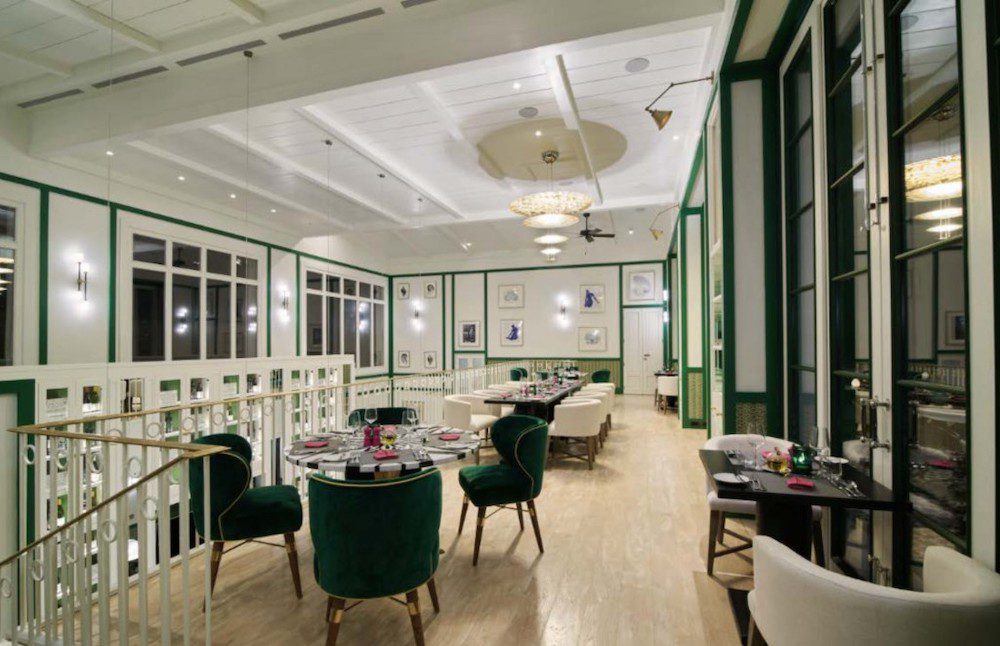 One amazing restaurant on Canouan Island in St. Vincent and the Grenadines is Foxy Jack's, this image shows one of the green accented dining rooms with comfortable plush chairs and high ceilings.