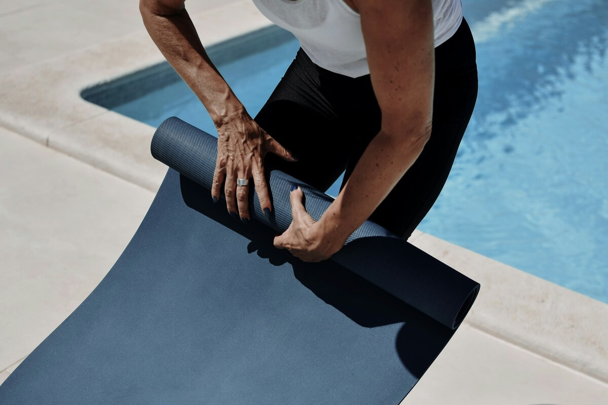 Yoga mat rolling up by the pool