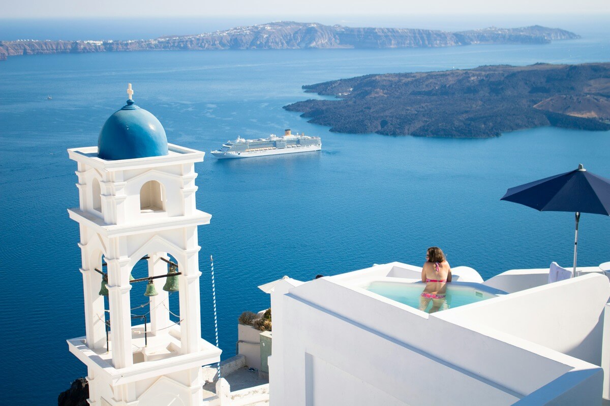 Woman in a rooftop pool in Santorini